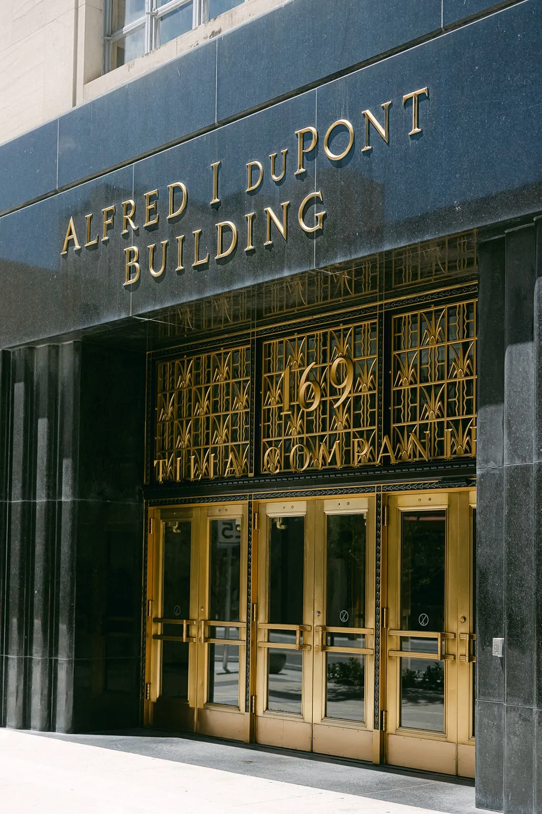Gold doors under the Alfred I. duPont Building sign at 169
